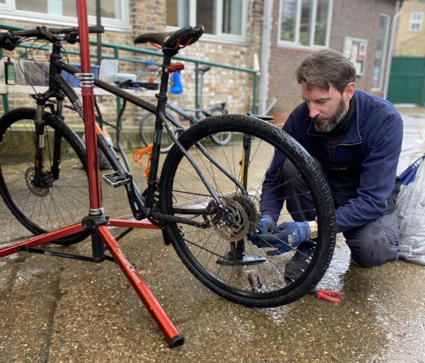 A man fixing up a bike at a repair workshop