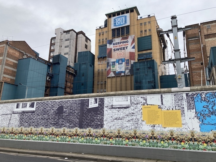 Sugar factory of tate and lyle with an illustrated fence in front of it
