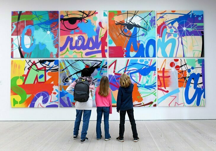 The people looking at a huge colourful canvas
