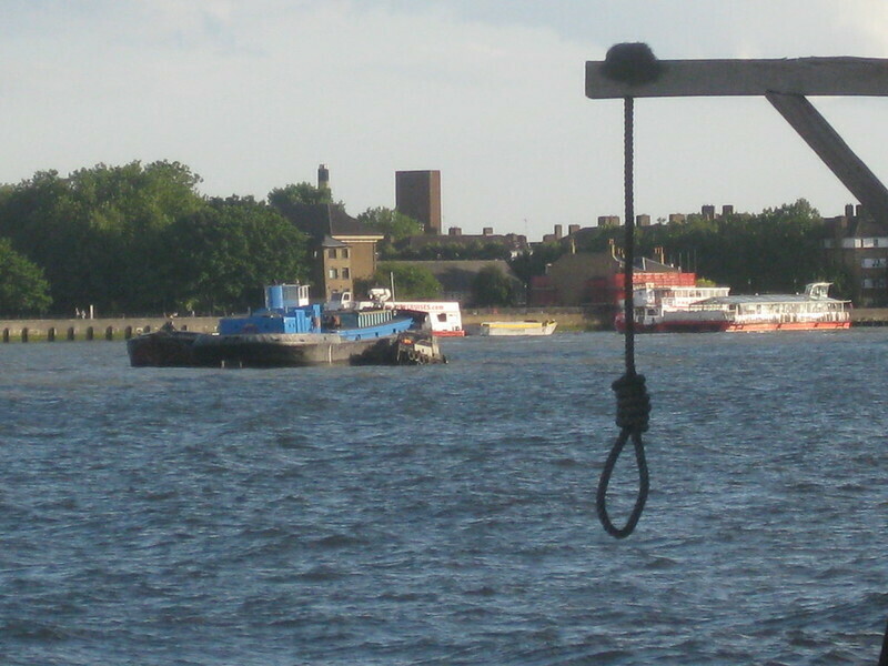 A noose swinging over the river Thames with boats in background