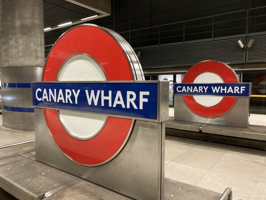 Two canary wharf tube roundels on a platform