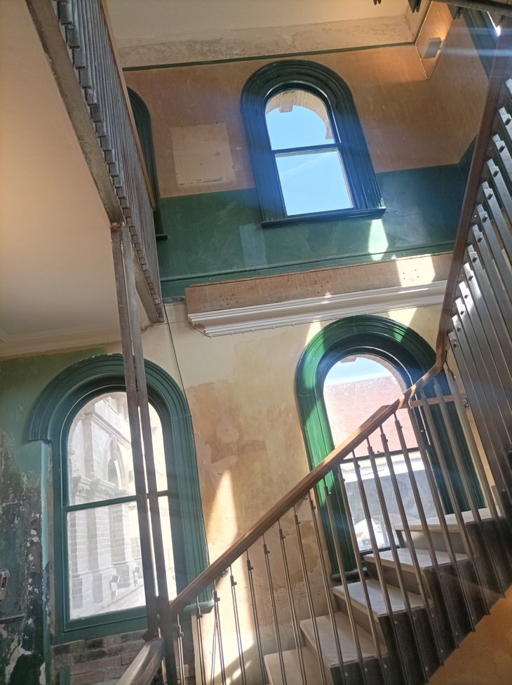 Green arches windows lined a Victorian stairwell stairwell