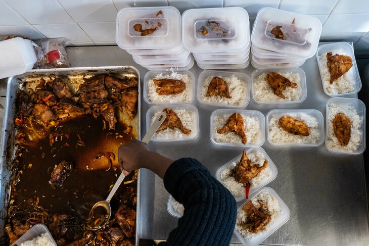 Windrush Day events 2023. Jerk chicken and rice being dished out into containers