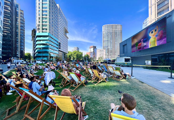 Free and cheap things to do: people sitting outside in deckchairs watching an animated film on a large screen at Paddington Basin