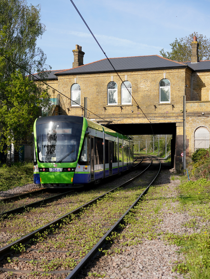 A tram passing under a Victorian station