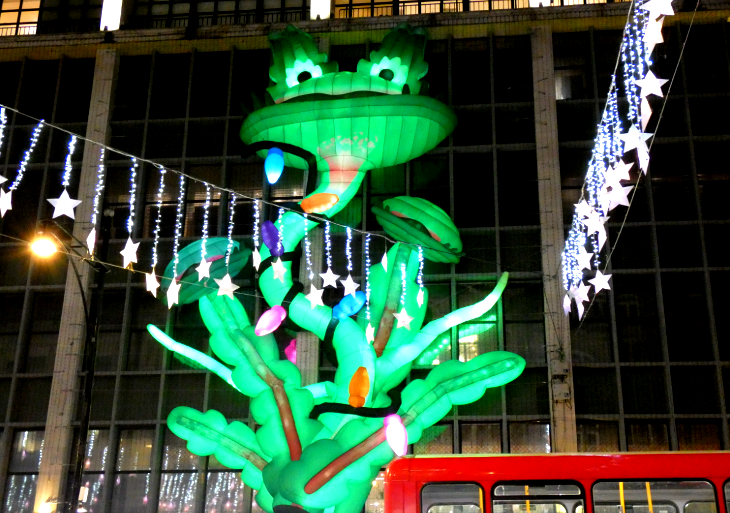 A giant inflatable plant - with a face that looks like a frog - spanning several floors of the front of John Lewis on Oxford Street