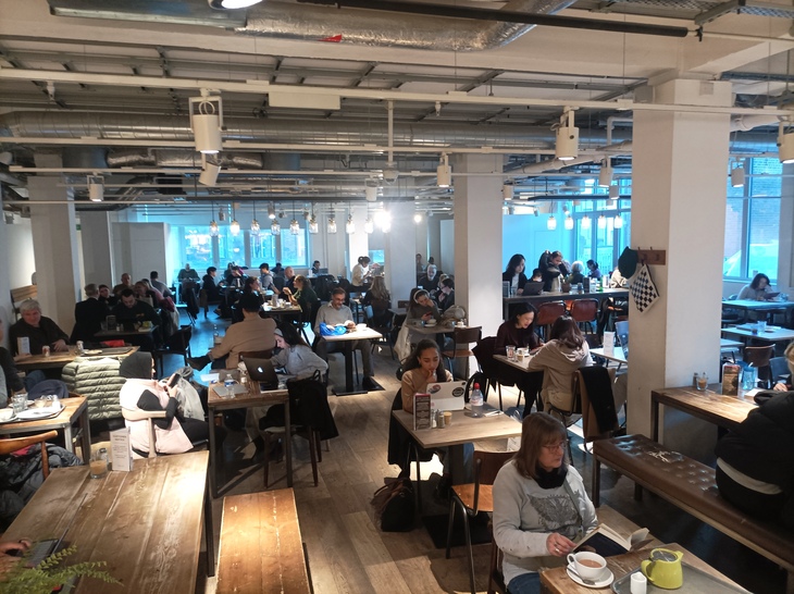 Hot desk spots in central London: People working and drinking in a large cafe