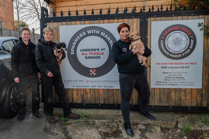 Mechanics standing in front of Spanners With Manners, London's first all female garage. Pictured Megan Kulcsar, Laura Kennedy holding her dog Tiny, and Siobhan Kennedy holding her dog Ralphy.