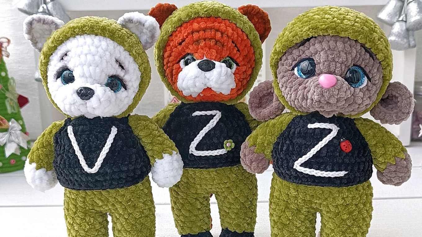 ‘Plush Troops’: The Pro-War Children’s Toys Taking Over Russia’s Online Marketplaces

Текст: “In this strategy game, you lead a battalion aiming to liberate Ukraine from Nazi rule,” reads the description of Russia’s first board game about the war in Ukraine.

The game,called“Special Operation on the Outskirts,” sells for about 1,600 rubles ($20) on Russian online marketplaces.

Inspired by Monopoly and designed for two to six players, the game challenges participants to occupy as many Ukrainian cities as possible. Instead of Monopoly money, players use a fictional currency featuring the faces of President Vladimir Putin, Foreign Minister Sergei Lavrov and former General Sergei Surovikin.

In the fourth year of the full-scale invasion, toys and merchandise featuring the pro-war Z symbol have become increasingly common on Russian marketplaces and social media.

Listings include everything from car dashboard decorations to toy soldiers for children.

“The plot grabs you from the first minutes. It’s great that part of the proceeds go to support participants of the special military operation. The perfect gift for patriots!”writesYekaterina, a recent buyer. Other reviewers share that they gave the game to their sons on Defenders of the Fatherland Day.

Another board game, “Couch Expert,” promises to educate players about the invasion.

Players have 30 seconds to answer questions about the progress of the “special operation.” Questions range from the late ultranationalist politician Vladimir Zhirinovsky’s position on the war to the roles of figures like Elon Musk and propagandist Olga Skabeyeva in shaping сoverage of the invasion.

“I ordered 11 of them for school as gifts for the boys. But I got lucky — the boxes came wrapped in film, so it’s not embarrassing to give them. Thanks,”writesa woman named Natalia in a review.

These toys span all price ranges, from an acrylic Z-minionto aroly-polytoy bearing the pro-war slogan “You can’t knock us down.” The latter sells for about 500 rubles ($6).

“The idea to create a patriotic roly-poly toy came five years ago, when the Russian team was banned from competing under the national flag at the Olympics in Korea,”saysDmitry Zavidov, director of the Kotovsky Roly-Polies company.

On VKontakte, Yulia from Moscowsells“knitted fighters” shaped like a tiger, mouse or dog. Each animal, stitched with a Z or V,costs1,500 rubles ($18). For an extra 250 rubles, Yulia offers to embroider a soldier’s callsign on the toy’s flak vest.

“Any other inscription of your choice is also possible (price depends on the size),”readsthe product description. On some marketplaces, similar toys arepricedat around 1,100 rubles ($14).

Another item on the market is a stuffedraccoonmarked with the Z symbol, a reference to the raccoon that Russian troops infamously stole from a zoo during their retreat from the southern Ukrainian city of Kherson.

Sellers alsoofferstuffed bears in military uniforms with Z and V insignia. In some cases, the toys arehandmadeby widows of Russian soldiers.

For younger children, “patriotic”coloring bookssell for about 300 rubles ($3.73).

“My child is four. He liked it,” says one mother in a review. Some parents post videos of their children coloring tanks and other Russian military equipment.

For about the same price, sellers alsooffera set of toy soldiers called the “Special Operation Recon Soldiers Set.”

“Toy figures of the Russian Armed Forces will delight children with their quality and design. They’re perfect for role-playing games and help develop creativity and imagination,” the manufacturer claims.

War-related games and toys may hold particular appeal for children,explainspsychologist Michael Brandl, a member of the German toy evaluation group Spiel Gut.

One reason for their appeal, he says, is that they offer positive reinforcement of the media and propaganda messaging that children encounter daily.

“From these sources, children form an image of a person they then try to imitate and act out in roleplay. Weapons and how to use them become part of the child’s perceived reality and a key attribute of the supposed image of the ‘ideal’ man,” Brandlwrote.

A child psychologist from Russia, whose name has been withheld for safety reasons, voiced a similar view.

“This is a protracted war, so the state and Vladimir Putin need boys, even from kindergarten, to already be preparing for the future battlefield,” the psychologist told The Moscow Times. “First, the state turns poor women into mothers who buy these toy soldiers. Then this Z-patriotism is nurtured with a mother’s milk. They’ll buy it without even noticing the Z, especially if it’s on sale.”

Marketplaces also offer stuffed cat car decorations in camouflage colors that cost about 500 rubles ($6.20). In addition to a toy with the Russian tricolor and the letter Z, the manufacturer alsooffersa version bearing the Wagner mercenary group’s skull emblem.

“You sent me a female cat, apparently — no male features and no Z. I specifically needed a male cat with a Z on it! I refused the order at pickup,”complainsa buyer named Elena. Other buyers note that the toy’s tail fell off quickly.

Even toy robots are marked with the Z symbol. A set of these toys costing 784 rubles ($9.70) includes a robot with a Russian flag and weapons. For an extra 200 rubles, itcomeswith a glow-in-the-dark Z.

“Satisfied with the purchase. Russia will win! Russia always wins!”saysMaria, who bought the Z-robot for her son, in her review.